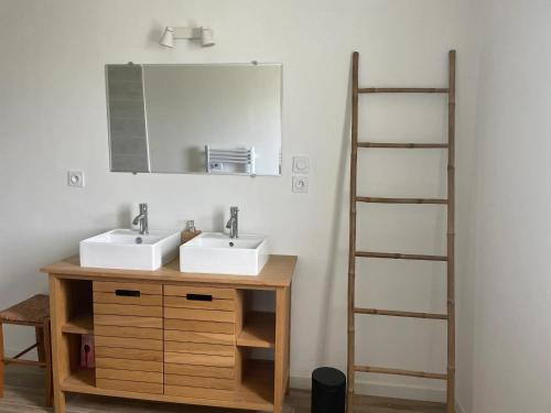 une salle de bain avec deux lavabos et un miroir dans l'établissement Maison familiale spacieuse à Plouguerneau avec jardin, à Plouguerneau
