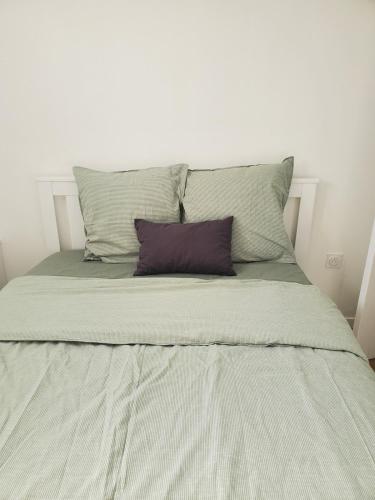 un lit blanc avec deux oreillers dessus dans l'établissement Appartement agréable, CDG, Astérix,Stade de France, à Stains