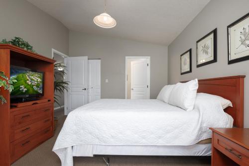 a bedroom with a bed and a flat screen tv at Paradise Canyon Golf Resort - Signature Villa 382 in Lethbridge