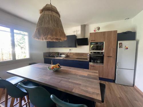 a kitchen with a table with a bowl of fruit on it at Villa Casa azul in Cuxac-dʼAude