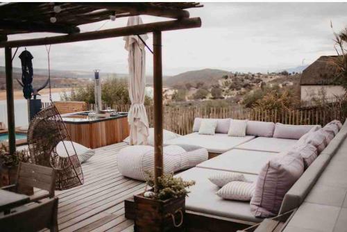 a wooden deck with white couches and an umbrella at Clanwilliam Dam House in Clanwilliam