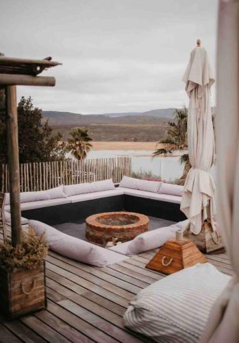 a patio with a couch and a fire pit on a deck at Clanwilliam Dam House in Clanwilliam