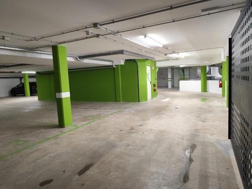 an empty parking garage with green columns in it at Apartamento a 400m de la playa en Ares, garaje incluído in Ares