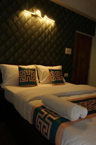 two beds in a bedroom with a large headboard at Hotel Sky High in Pakyong