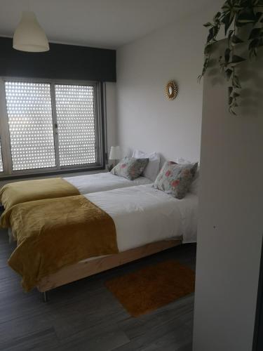 a bedroom with a large bed and a window at SunHouse Alojamentos in Senhora da Hora