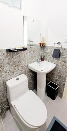 a bathroom with a white toilet and a sink at Bougainvillea guesthouse in San Juan