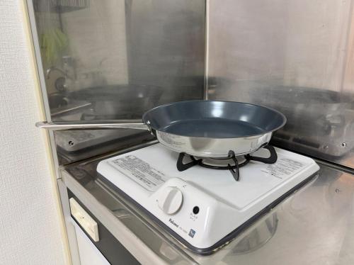 a pan sitting on top of a stove at ZenAbode, 5-minute walk from Taiko-dori Station, 1-minute train ride from Nagoya Station, excellent location for sightseeing in Nagoya in Nagoya