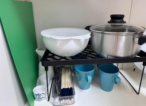 a shelf with a bowl and other kitchen utensils at ZenAbode, 5-minute walk from Taiko-dori Station, 1-minute train ride from Nagoya Station, excellent location for sightseeing in Nagoya in Nagoya