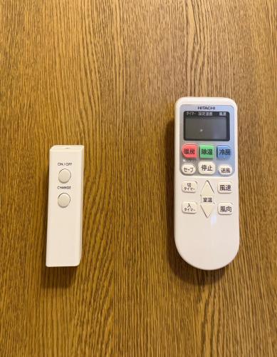 two remote controls sitting on top of a table at ZenAbode, 5-minute walk from Taiko-dori Station, 1-minute train ride from Nagoya Station, excellent location for sightseeing in Nagoya in Nagoya