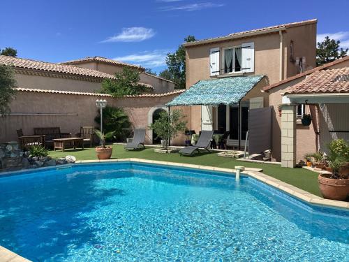 a swimming pool in the backyard of a house at Joli duplex au cœur de la Drôme Provençale in Donzère