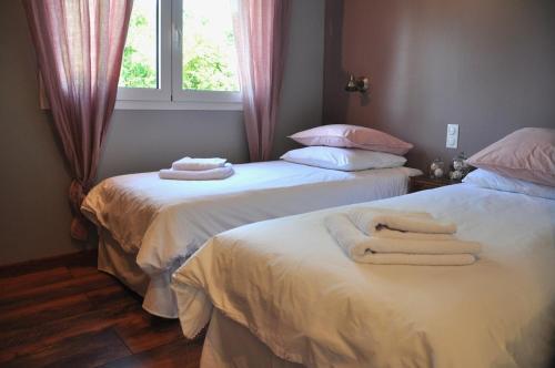 two beds in a room with towels on them at Le Séchoir, au Jardin des Tisanes in Tabanac
