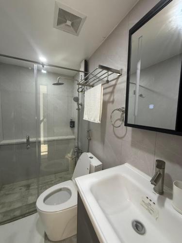a bathroom with a toilet and a sink and a shower at Seastar Resort By ZACE in Santiago