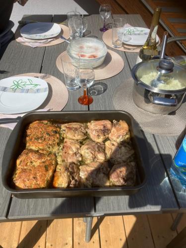 a table with a pan of food on top of it at Relax Apartman in Sümeg
