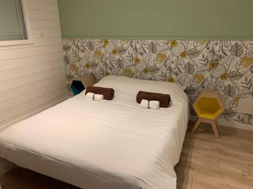 - un lit blanc avec 2 serviettes brunes dans l'établissement Gîte du marais 2, à Beauvoir-sur-Mer