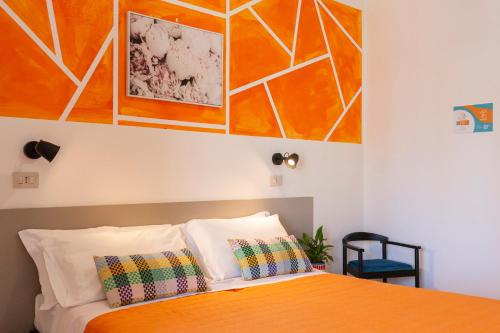 a bedroom with an orange bed with two pillows at Hotel A Casa Nostra in Rimini