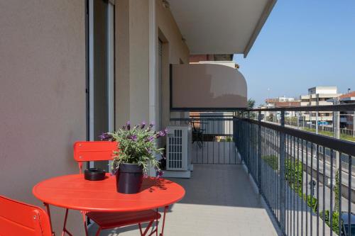 a red table and chairs on a balcony at Hotel A Casa Nostra in Rimini
