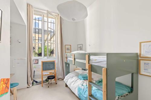 une chambre avec deux lits superposés et une fenêtre dans l'établissement Comme une maison sur l'Île Saint Louis, à Paris