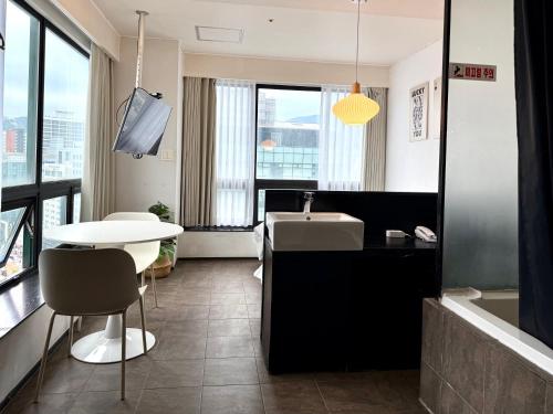 a bathroom with a sink and a table and a tub at Mini Hotel May Nampo in Busan