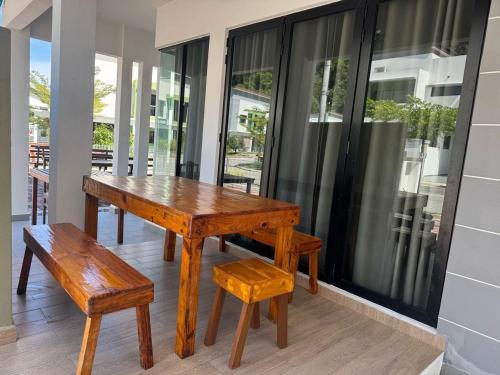 ein Holztisch und eine Bank auf einer Veranda in der Unterkunft Pangkor L30 88 Corner villa House in Pulau Pangkor