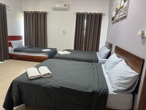 zwei Betten in einem Hotelzimmer mit Handtüchern darauf in der Unterkunft Pangkor L30 88 Corner villa House in Pulau Pangkor