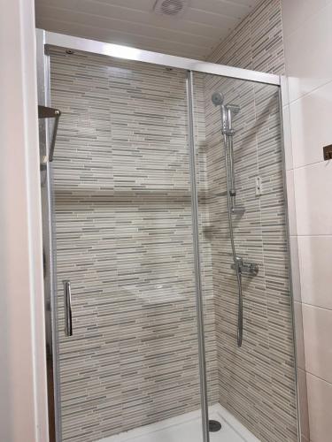 a shower with a glass door in a bathroom at Casa Dona Alzira in Arganil