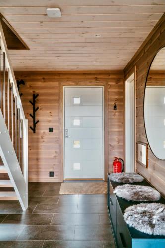 a room with wooden walls and a staircase and a door at Spacious, modern cabin Ramberg Lofoten in Ramberg