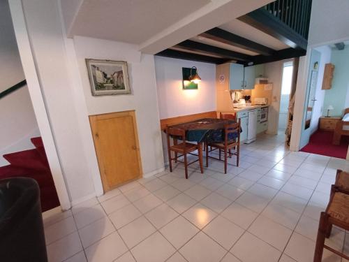 une cuisine et une salle à manger avec une table et des chaises dans l'établissement Maison à ROYAN PONTAILLAC, à Royan
