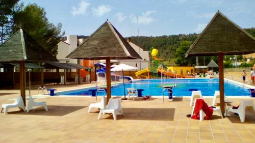 a swimming pool with white chairs and a pool at Aer Rural Apartment - Casillas Valle de Ayora in Jalance