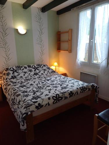 une chambre avec un lit avec une couette noire et blanche dans l'établissement Maison à ROYAN PONTAILLAC, à Royan