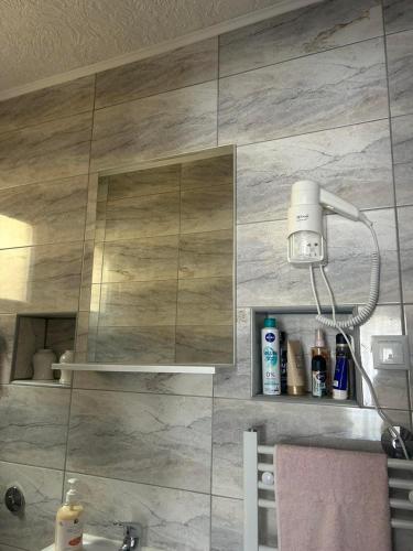 a bathroom with a shower with a tile wall at Naid Apartmani in Kulen Vakuf