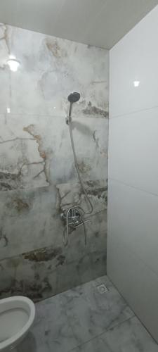 un bagno con wc e parete in marmo di Ganja house a Ganja