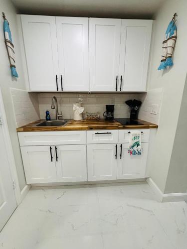 a kitchen with white cabinets and a sink at Villa Tortuga in Fort Myers