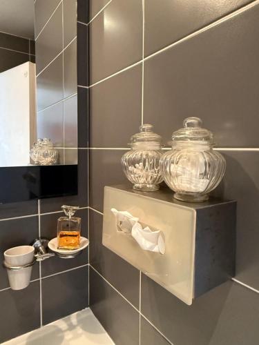 - une salle de bains pourvue de deux bocaux en verre et d'une plaque de cuisson dans l'établissement Beautiful flat on Capitole Place, à Toulouse