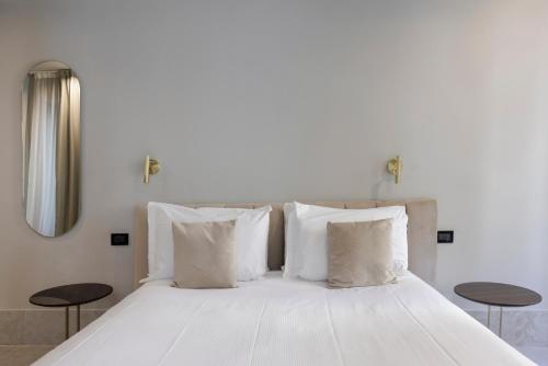 a bed with white sheets and pillows in a room at Palazzo Bellezia Luxury Suites & Spa in Turin