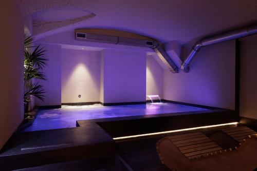a room with purple lights on a stage with a couch at Palazzo Bellezia Luxury Suites & Spa in Turin