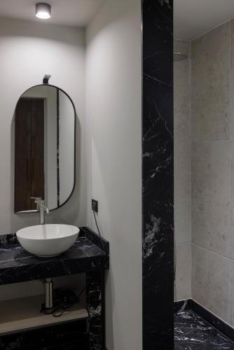 a bathroom with a sink and a mirror at Palazzo Bellezia Luxury Suites & Spa in Turin
