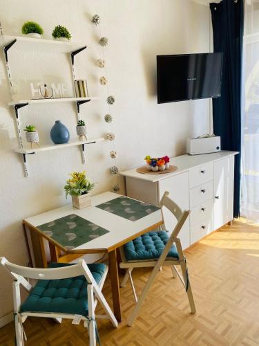 Cette chambre dispose d'une table, de deux chaises et d'un bureau. dans l'établissement La vie en bleu, à Lamalou-les-Bains