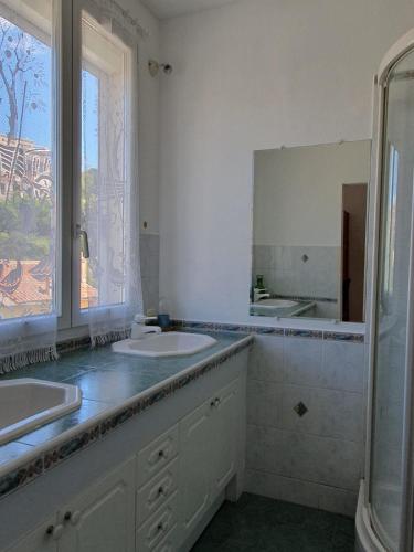 une salle de bain avec deux lavabos et un grand miroir dans l'établissement Chambre Proche Plage du Prophète, à Marseille
