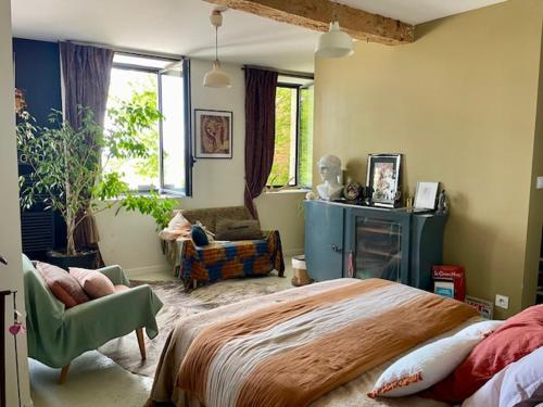 une chambre avec un lit, une chaise et une fenêtre dans l'établissement Maison Bohème, à Verfeil