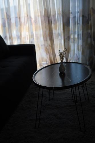 a coffee table with a vase on it in front of a window at Forest-Riversend in Pietermaritzburg
