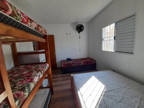 une chambre avec deux lits superposés et une fenêtre dans l'établissement Chácara Fazendinha Oliveira, à Mogi das Cruzes