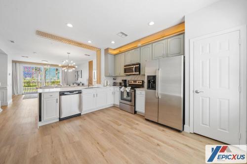 a kitchen with white cabinets and a large white refrigerator at The Epic Toronto Vista Cay Orlando in Orlando