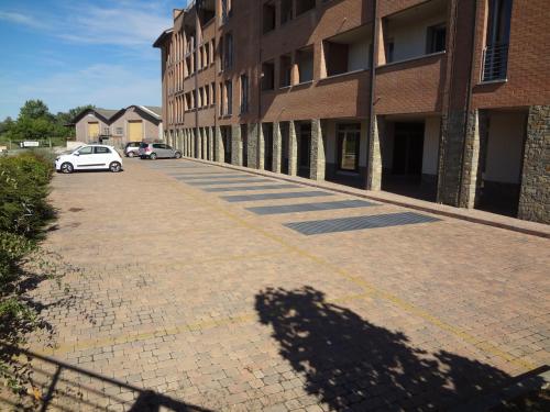 a shadow of a car parked on a brick street at La trifula bianca apts. in Alba