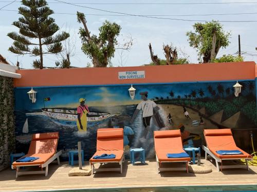a mural on the side of a building with chairs at Havre De Paix in Somone