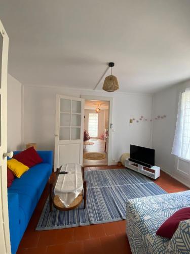 un salon avec un canapé bleu et une télévision dans l'établissement Bright apartment in the historic center, à Marseillan