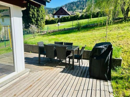 a patio with a table and chairs and a trash can at Appartement duplex spacieux in Fleurier