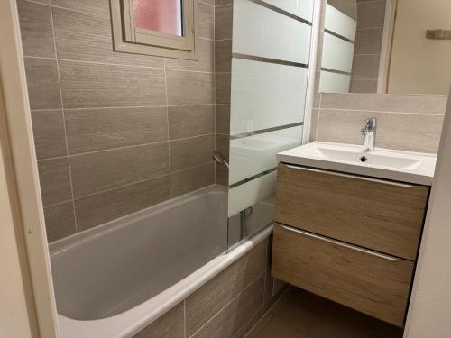 une salle de bain avec une baignoire, un lavabo et une douche dans l'établissement Studio climatisé avec piscine et parking privé, à Fréjus
