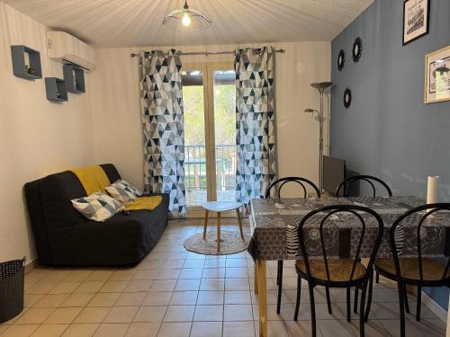 un salon avec une table et un canapé dans l'établissement Studio climatisé avec piscine et parking privé, à Fréjus