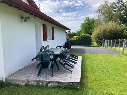 une table et des chaises assises à l'extérieur d'une maison dans l'établissement Appartement Jatxou, à Jatxou