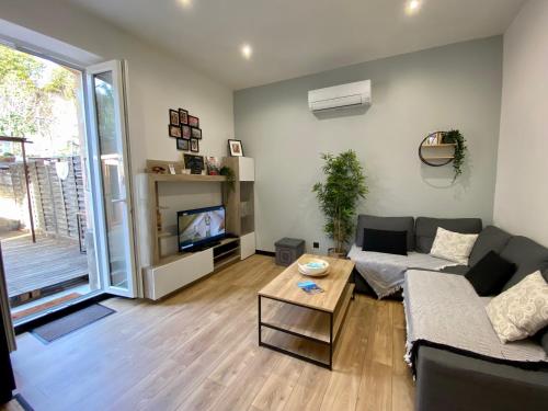 a living room with a couch and a table at Charmant Petit studio proche Centre et Plage in Banyuls-sur-Mer